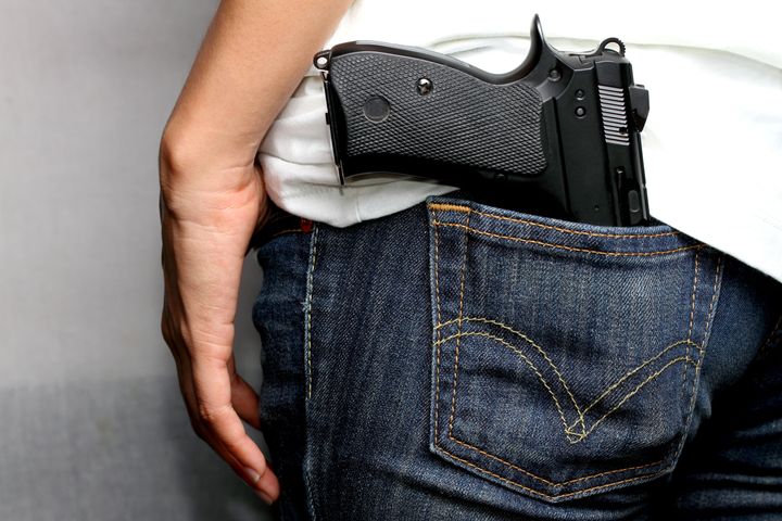 gun in woman jeans pocket ...