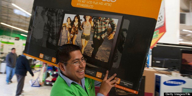 An employee carries a Polaroid Corp. 40 inch LCD television to a cash register inside Wal-Mart de Mexico SAB de CV's Bodega A