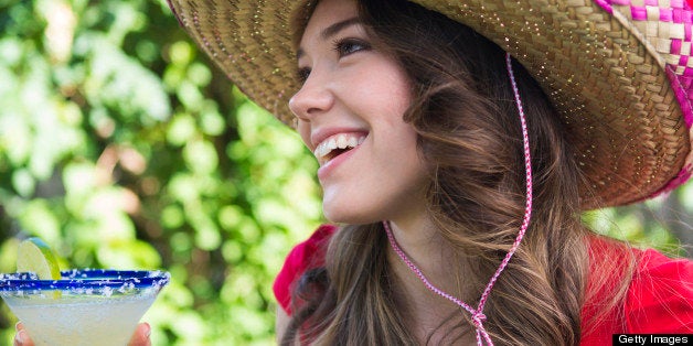 Woman with a margarita wearing a sombrero