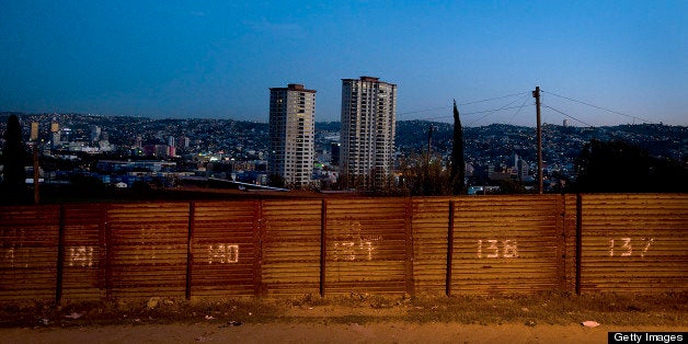 The city of Tijuana, Mexico, stands beyond the U.S.-Mexico border fence in San Diego, California, U.S. on Wednesday, March 21, 2012. Mexico's peso rose, paring its second weekly decline, amid speculation exporters are selling dollars to raise funds for tax payments before a month-end deadline. Photographer: Sam Hodgson/Bloomberg via Getty Images 