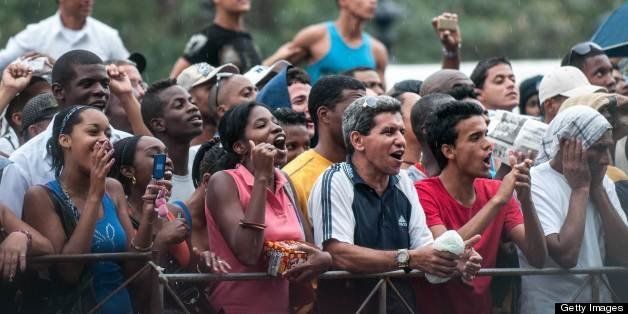 Cubans cheer as they wait to see US singer Beyonce in front of the Saratoga Hotel in Havana on April 5, 2013. Pop diva Beyonce and her rapper husband Jay-Z on Thursday created a stir as they toured the streets of Old Havana, with hundreds of Cubans turning out to catch a glimpse of the US power couple. AFP PHOTO/STR (Photo credit should read STR/AFP/Getty Images)