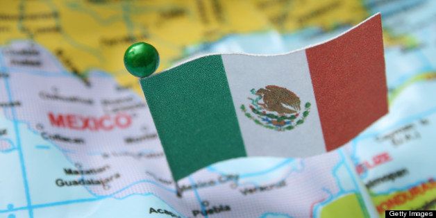 Mexican flag over cheap plastic map pointing Mexico City