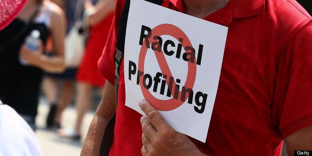 WASHINGTON - JULY 07: A man holds a sign against racial profiling during a protest with Community and faith leaders from Ariz