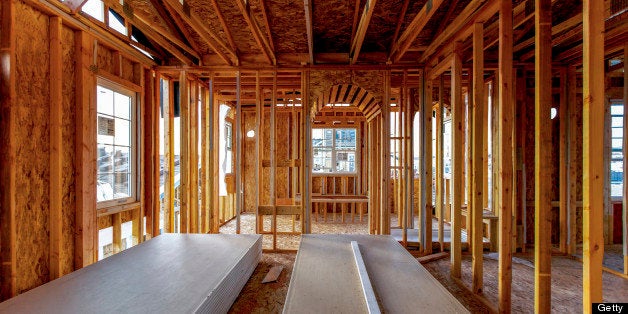 The interior of a building still under construction. Wood studs showing, no walls complete. Looking out through newly install