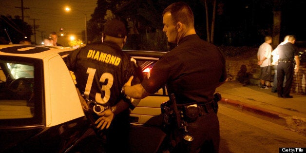 LOS ANGELES - AUGUST 4: (US NEWS AND WORLD REPORT AND NEWSWEEK OUT) A member of the Diamond Street hispanic street gang is helped into a Los Angeles Police Department gang unit car following his arrest for drug possession after his car was pulled over and searched by Los Angeles police on August 5, 2006 in the Rampart neighborhood in Los Angeles, California. The vehicle's driver, left, known as 'Lumpy,' is a veteran gang member and a known drug dealer. Police pulled him over as he was driving a new 4-door Lexus with marijuana smoke spewing out of the sunroof. Police were about to issue a simple citation for marijuana possession when another gang policeman uncovered 3 ounces of pure crack cocaine with a street value of over $5000 hidden behind the rear seat. All three were put under arrest with a felony charge. More crack cocaine was found hidden in their shoes. The Diamond Street gang is one Los Angeles's oldest hispanic street gangs. Lumpy's two passengers are not Diamond Street members. (Photo by Robert Nickelserg/Getty Images)