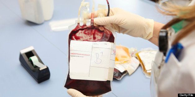 Doctor in a blood bank is holding blood bag with red blood cells