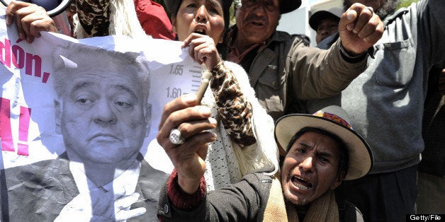 Residents from El Alto protest in front of the US embassy in La Paz on October 17, 2012 to demand the extradition of Bolivian former president Gonzalo Sanchez de Lozada (poster), now in exile in the United States. Sanchez de Lozada resigned in October 2003 and fled the country amid riots in which 65 people die over his deals with foreign oil companies. The La Paz government in 2008 requested that Washington extradite the aging former leader, so that he could be tried, but US authorities have not handed him over. AFP PHOTO/JORGE BERNAL (Photo credit should read JORGE BERNAL/AFP/Getty Images)