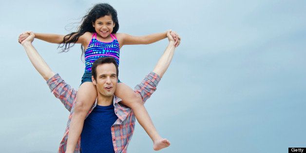 Loving Hispanic father with his daughter on the beach
