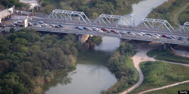 BROWNSVILLE TX - MAY 21: Cars drive from Matomoros, Mexico (L), across the U.S.-Mexico border at the Rio Grande on May 21, 2013 into Brownsville, Texas. The area is active for legal international commerce as well as drug smugglers bringing their product north from Mexico into the United States. (Photo by John Moore/Getty Images)