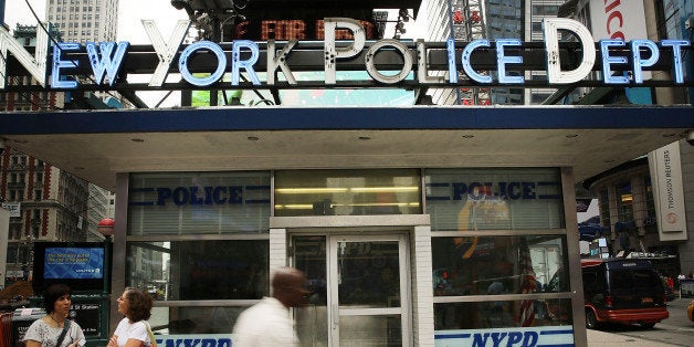 NEW YORK, NY - AUGUST 12: People walk by a New York Police Department (NYPD) outpost in Times Square on August 12, 2013 in N