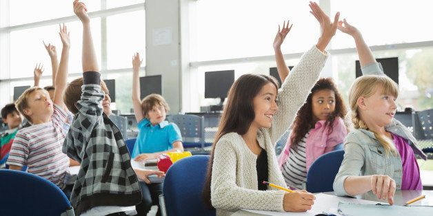 Students with hands raised in classroom