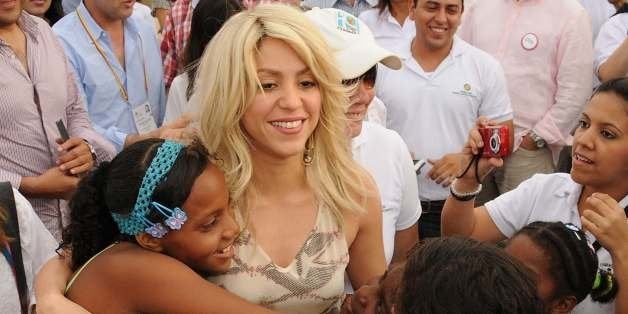Colombian singer Shakira (C) greets children upon arrival for the launching of the 'Primero es lo primero' programme, in Cart
