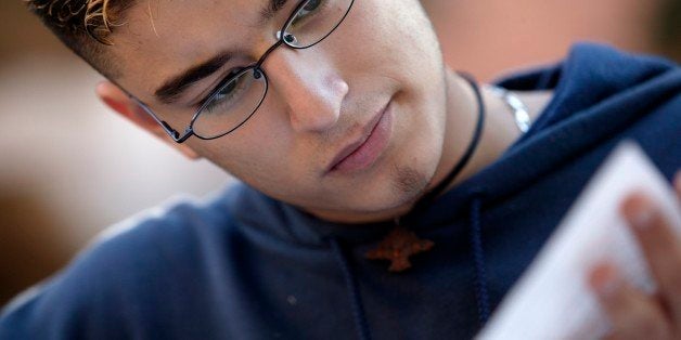 A young hispanic male works on his homework.