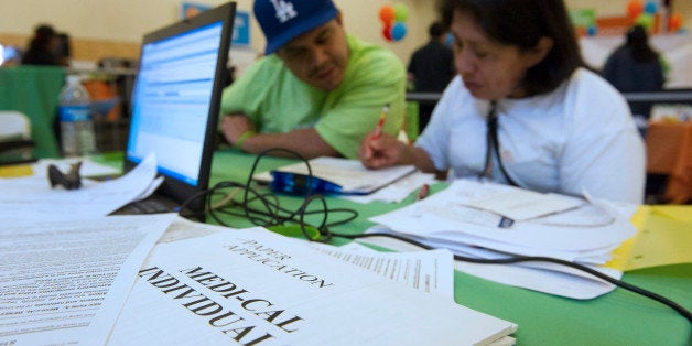 An attendee, right, fills out an health care application with a volunteer during the WeConnect Health Enrollment Information & Wellness Event in Oakland, California, U.S., on Saturday, Sept. 21, 2013. The battle over Obamacare is taking on political importance as Democrats hope a successful roll-out among Hispanics will further bind those voters to the Democratic Party and undermine Republican efforts to build more support before the 2016 presidential election. Photographer: David Paul Morris/Bloomberg via Getty Images