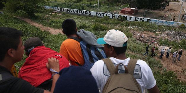 IXTEPEC, MEXICO - AUGUST 06: Central American immigrants arrive on top of a freight train to the Hermanos en el Camino immigrant shelter on August 6, 2013 in Ixtepec, Mexico. The sign outside reads 'Welcome Migrants.' Thousands of Central American migrants ride the trains, known as 'la bestia', or the beast, during their long and perilous journey north through Mexico to reach the United States border. Some of the immigrants are robbed and assaulted by gangs who control the train tops, while others fall asleep and tumble down, losing limbs or perishing under the wheels of the trains. Only a fraction of the immigrants who start the journey in Central America will traverse Mexico completely unscathed - and all this before illegally entering the United States and facing the considerable U.S. border security apparatus designed to track, detain and deport them. (Photo by John Moore/Getty Images)