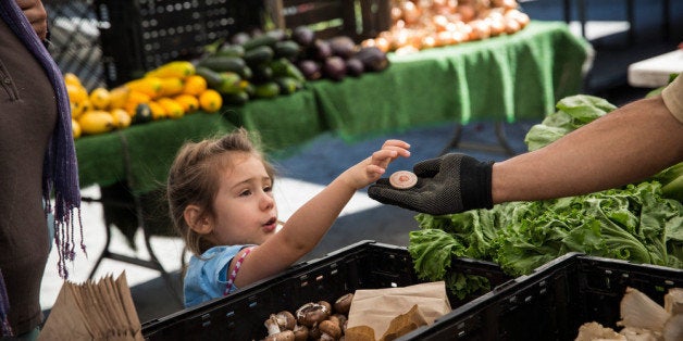 NEW YORK, NY - SEPTEMBER 18: A girl pays for her mother's groceries using Electronic Benefits Transfer (EBT) tokens, more commonly known as Food Stamps, at the GrowNYC Greenmarket in Union Square on September 18, 2013 in New York City. According to a Gallup poll released earlier this month, 20% of American adults struggled to buy enough food at some point in the last year. The rate of hungry people in America has gone relatively unchanged since 2008, suggesting the economic recovery since the 2008 recession may be disproportionately affecting the wealthy. More than 50 of GrowNYC's Greenmarket's now accept EBT; over $800,000 in sales were complete with EBT payment at the Greenmarket's in 2012. GrowNYC is also currently offering a program known as Health Bucks: for ever $5 spent using EBT at a Greenmarket, GrowNYC provides an additional $2, which can be spent specifically on fresh fruits and vegetables. (Photo by Andrew Burton/Getty Images)
