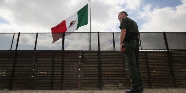 SAN YSIDRO, CA - OCTOBER 03: U.S. Border Patrol agent Jerry Conlin stands on the American side of the U.S.-Mexico border fence on October 3, 2013 at San Ysidro, California. While hundreds of thousands of government workers were furloughed due to the federal shutdown, thousands of Border Patrol agents, air-traffic controllers, prison guards and other federal employees deemed 'essential' remain on duty, although their pay may be delayed. (Photo by John Moore/Getty Images)