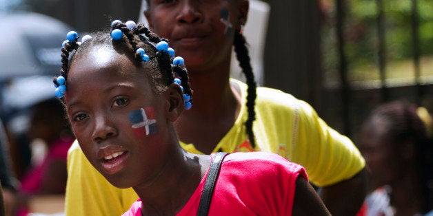 Haitians with the Dominican flag painted on their cheeks demonstrate in front of the Central Electoral Board to demand their Dominican citizenship in Santo Domingo on March 12, 2013. AFP PHOTO / Erika SANTELICES (Photo credit should read ERIKA SANTELICES/AFP/Getty Images)