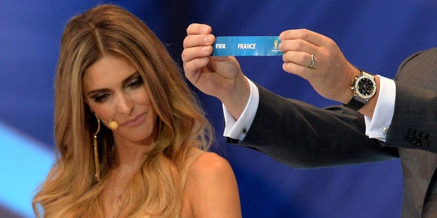 FIFA Secretary General Jerome Valcke shows the name of Belgium next to presenter Fernanda Lima during the final draw of the g