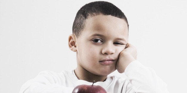 african boy at desk with apple