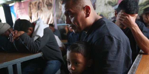 NOGALES, MEXICO - MARCH 10: Javier Guerrero from Mexico attends a Catholic Mass with his visiting son, Javier Jr. (3), a U.S. citizen, at the Kino Border Initiative center for immigrants near the U.S.-Mexico border on March 10, 2013 in Nogales, Mexico. He is married to American citizen Lace Rodriguez, and the family had lived together in Phoenix. Guerrero, an undocumented worker from Mexico, said he was detained by the U.S. Border Patrol after being stopped for speeding and drug possession, held for three months by ICE and then deported March 4 to Nogales, Mexico. Guerrero had lived in the United States for 17 years. He and Rodriguez, a medical student, have two children, and she is nine-months pregnant with a third. The splitting up of families has become a major issue as the U.S. works towards immigration reform. (Photo by John Moore/Getty Images)