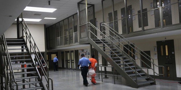 ADELANTO, CA - NOVEMBER 15: A guard escorts an immigrant detainee from his 'segregation cell' back into the general populatio