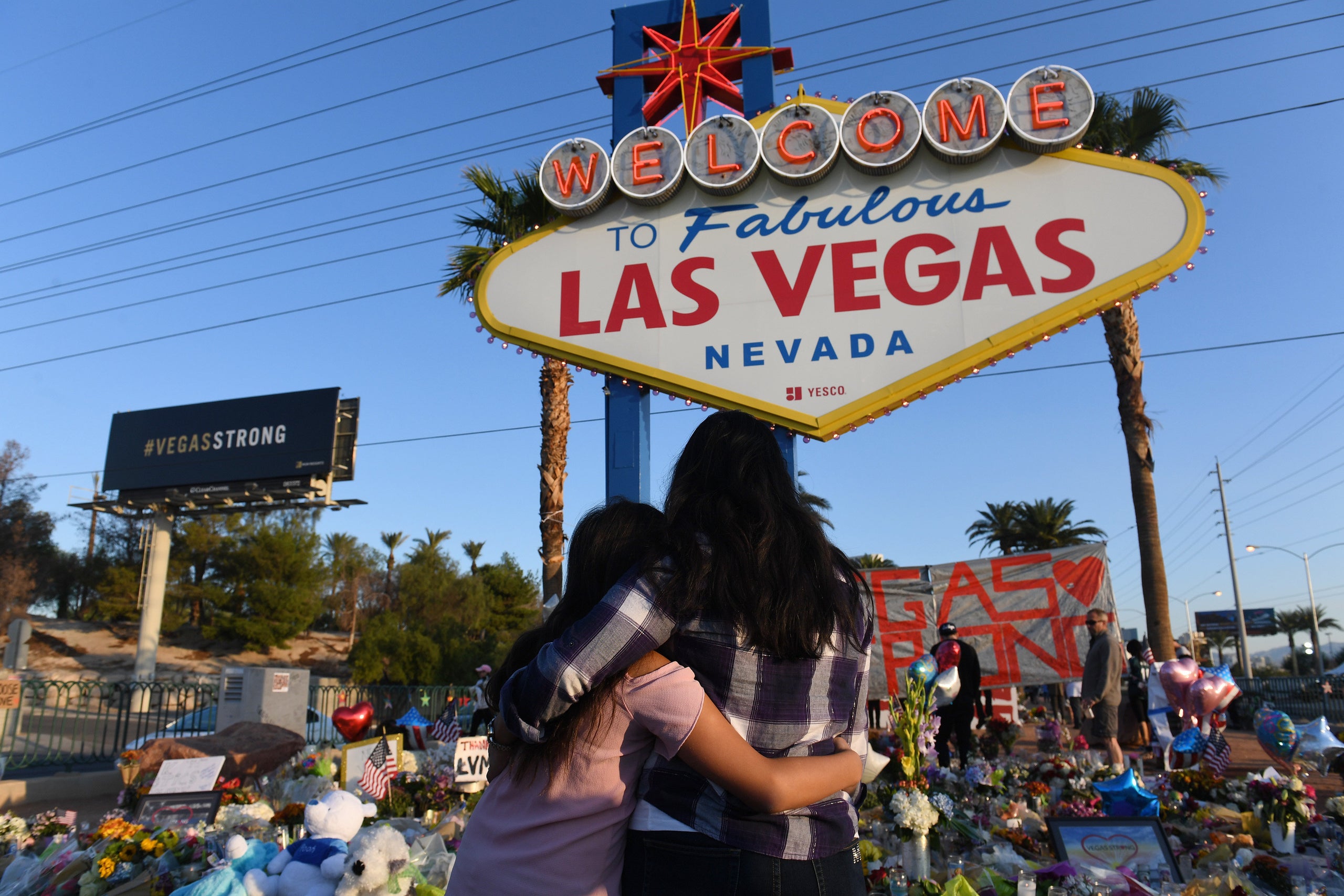 People visit a makeshift memorial to the victims of the Oct. 1, 2017, massacre at an outdoor concert in Las Vegas. The g
