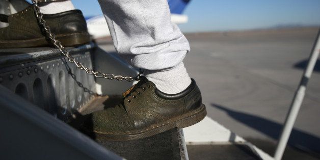 MESA, AZ - FEBRUARY 28: A Honduran immigration detainee, his feet shackled and shoes laceless as a security precaution, boards a deportation flight to San Pedro Sula, Honduras on February 28, 2013 in Mesa, Arizona. U.S. Immigration and Customs Enforcement (ICE), operates 4-5 flights per week from Mesa to Central America, deporting hundreds of undocumented immigrants detained in western states of the U.S. With the possibility of federal budget sequestration, Most detainees typically remain in custody for several weeks before they are deported to their home country, while others remain for longer periods while their immigration cases work through the courts. (Photo by John Moore/Getty Images)