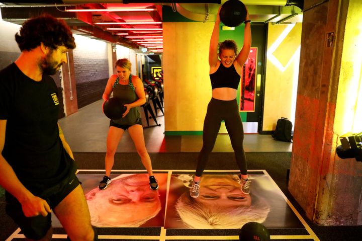 A gym member drop balls on images of Britain's Prime Minister Theresa May and Labour leader Jeremy Corbyn during a Brexfit gym class at Gym Box in London.