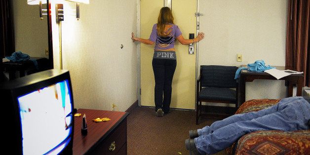 COLLEGE PARK, MD - NOVEMBER 30:A female officer, in character, watches for approaching clients in her motel room as Prince Georges police run a sting operation to nab prostitutes and johns on November, 30, 2012 in College Park, MD.(Photo by Bill O'Leary/The Washington Post via Getty Images)