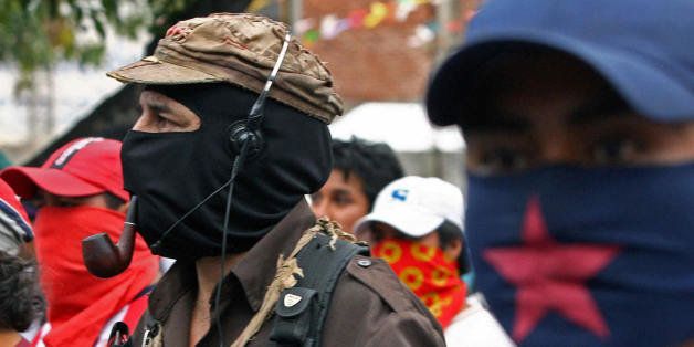 Texcoco, MEXICO: The leader of the Mexican Zapatista Army for National Liberation (EZLN) 'Subcomandante Marcos' (L), joins thousands of workers and students in a rally in Texcoco, in the state of Mexico, 05 May 2006, in support of the citizens of this city and of San Salvador Atenco who clashed with the police on Wednesday when street vendors violently resisted efforts to relocate them. AFP PHOTO/OMAR TORRES (Photo credit should read OMAR TORRES/AFP/Getty Images)