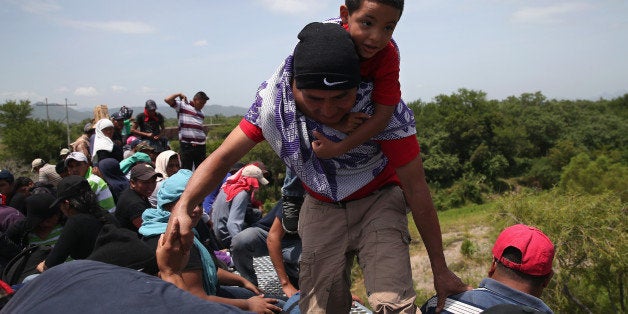 IXTEPEC, MEXICO - AUGUST 06: Central American immigrants arrive on top of a freight train for a stop on August 6, 2013 in Ixtepec, Mexico. Thousands of Central American migrants ride the trains, known as 'la bestia', or the beast, during their long and perilous journey north through Mexico to reach the United States border. Some of the immigrants are robbed and assaulted by gangs who control the train tops, while others fall asleep and tumble down, losing limbs or perishing under the wheels of the trains. Only a fraction of the immigrants who start the journey in Central America will traverse Mexico completely unscathed - and all this before illegally entering the United States and facing the considerable U.S. border security apparatus designed to track, detain and deport them. (Photo by John Moore/Getty Images)