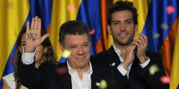 Colombian President and presidential candidate Juan Manuel Santos shows the palm of his hand reading 'Peace' as he celebrates after knowing the results of the runoff presidential election on June 15, 2014, in Bogota. Santos was re-elected with 50.90 percent of the vote, compared with 45.04 percent for the more conservative Oscar Ivan Zuluaga, with 99.37 percent of votes tallied. AFP PHOTO/Guillermo LEGARIA (Photo credit should read GUILLERMO LEGARIA/AFP/Getty Images)