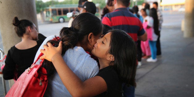 MCALLEN, TX - JULY 25: Immigrants embrace at the Greyhound bus station before departing to various U.S. destinations on July