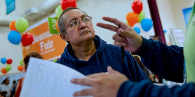 An attendee speaks with a health care volunteer during the WeConnect Health Enrollment Information & Wellness Event in Oakland, California, U.S., on Saturday, Sept. 21, 2013. The battle over Obamacare is taking on political importance as Democrats hope a successful roll-out among Hispanics will further bind those voters to the Democratic Party and undermine Republican efforts to build more support before the 2016 presidential election. Photographer: David Paul Morris/Bloomberg via Getty Images