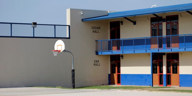 A basketball goal is seen in the courtyard at the Karnes County Residential Center, Thursday, July 31, 2014, in Karnes City, Texas. Federal officials gave a tour of the immigration detention facility that has been retooled to house adults with children who have been apprehended at the border. (AP Photo/Eric Gay)