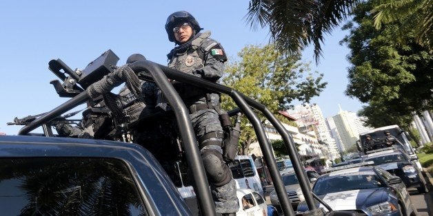 Mexican federal policemen patrol a street in Acapulco, Guerrero state, Mexico on December 3, 2014. Mexican federal forces arrived to the port of Acapulco to strengthen security. AFP PHOTO / Pedro PARDO (Photo credit should read Pedro PARDO/AFP/Getty Images)