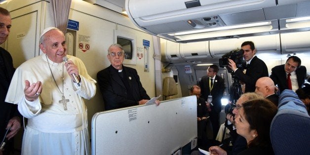 Pope Francis addresses journalist sitting onboard a plane during his trip back to Rome, on January 19, 2015 from the Philippines. The 78-year-old pontiff wrapped up a triumphant visit to the Philippines and Sri Lanka, seeking to promote the Catholic Church in one of its most important growth regions. AFP PHOTO / GIUSEPPE CACACE (Photo credit should read GIUSEPPE CACACE/AFP/Getty Images)