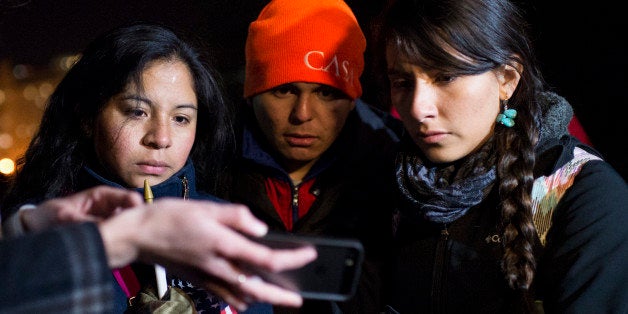 UNITED STATES - NOVEMBER 20: Immigration reform activists in front of the White House use a smartphone to watch President Bar