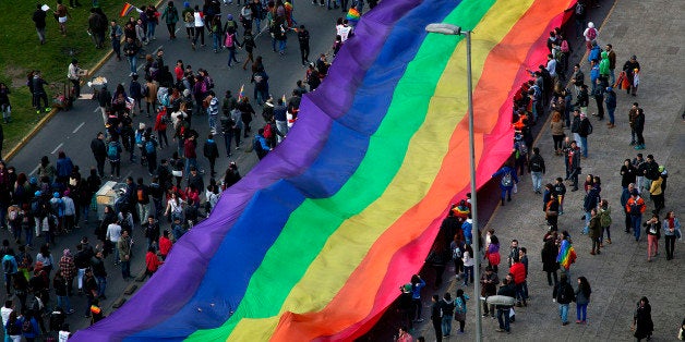 People wave a huge rainbow flag during the Gay Pride Parade in Santiago on June 22, 2013. AFP PHOTO/ CLAUDIO SANTANA (Photo credit should read CLAUDIO SANTANA/AFP/Getty Images)