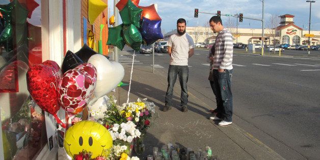 In this Feb. 18, 2015 photo, pedestrians view a memorial in Pasco, Wash., on the sidewalk where Antonio Zambrano-Montes, an unarmed man who was running away from police at a crowded intersection, fell after being fatally shot by police. (AP Photo/Nicholas K. Geranios)