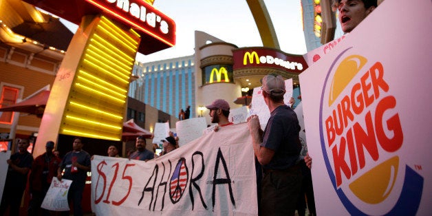 FILE - In this Sept. 4, 2014 file photo, protestors, including Kris Varrette, right, chant for increased wages and union rights at fast food restaurants in Las Vegas. Wal-Martâs decision to raise hourly wages for its lowest-paid workers provides a glimmer of hope for others working at minimum wage or just above. Other retailers and fast food restaurants may now follow suit in order to hold on to employees. (AP Photo/John Locher, File)