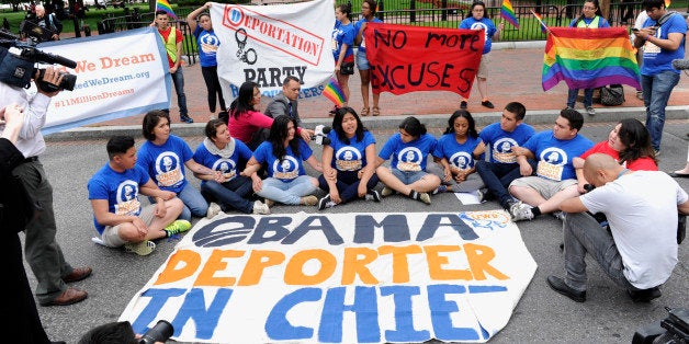 Protestors block traffic near the White House in Washington, rear, Thursday, June 5, 2014. In response to President Obamaâs decision to delay the deportation review he ordered from the Department of Homeland Security, United We Dream protested near the White House to highlight the urgency of the administration acting now. (AP Photo/Susan Walsh)