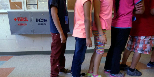 Detained immigrant children line up in the cafeteria at the Karnes County Residential Center, a temporary home for immigrant women and children detained at the border, Wednesday, Sept. 10, 2014, in Karnes City, Texas. Federal authorities want to build a similar immigration lockup facility for families in Dilley, Texas, south of San Antonio amid an unprecedented surge in the number of youngsters pouring across the U.S. border, a federal official said Thursday. (AP Photo/Eric Gay)