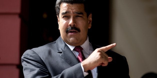 FILE - In this May 16, 2014 file photo, Venezuela's President Nicolas Maduro stands outside the Miraflores Presidential Palace where he received Palestine's President Mahmoud Abbas, in Caracas, Venezuela. Maduro said Thursday, May 29, 2014, the passage of legislation to impose sanctions on officials could cause his country to shut down its diplomatic missions in the United States, but he praised the Obama administration's opposition to the bill and said it has led him to name a new top diplomat in Washington. (AP Photo/Fernando Llano, File)