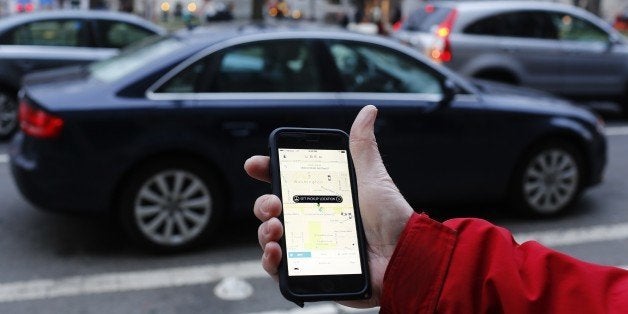 An UBER application is shown as cars drive by in Washington, DC on March 25, 2015. Uber said it was ramping up safety in response to rape allegations against a driver in India and growing concerns about background checks for operators of the popular ride-sharing service. In other cities where Uber operates, critics had complained that a lack of licensing and background checks of drivers could imperil those who use the service. AFP PHOTO/ ANDREW CABALLERO-REYNOLDS (Photo credit should read Andrew Caballero-Reynolds/AFP/Getty Images)