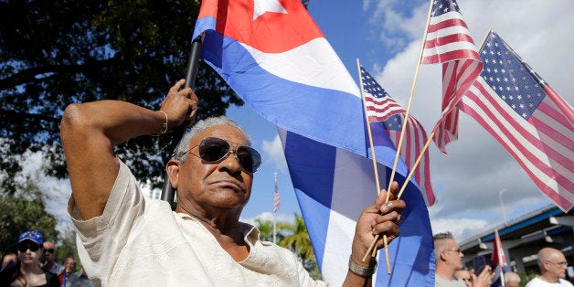 Evilio Ordonez holds Cuban and American flags during a protest against President Barack Obama's plan to normalize relations w