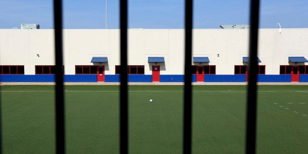 An artificial turf soccer field sits in the middle of the Karnes County Residential Center, Thursday, July 31, 2014, in Karnes City, Texas. Federal officials gave a tour of the immigration detention facility that has been retooled to house adults with children who have been apprehended at the border. (AP Photo/Eric Gay)