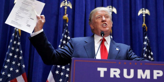 Developer Donald Trump displays a copy of his net worth during his announcement that he will seek the Republican nomination for president, Tuesday, June 16, 2015, in the lobby of Trump Tower in New York. (AP Photo/Richard Drew)