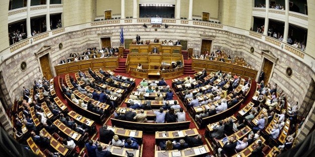 Greek Prime Minister Alexis Tsipras (rear C) delivers a speech during a parliamentary session at the Greek Parliament in Athe